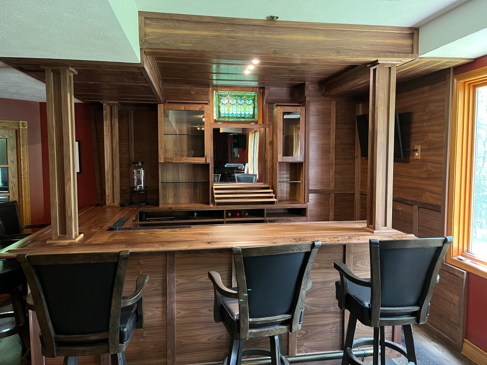Inspiration for an expansive contemporary l-shaped home bar in Omaha with no sink, shaker cabinets, dark wood cabinets, wood benchtops, brown splashback, timber splashback, laminate floors, brown floor and brown benchtop.