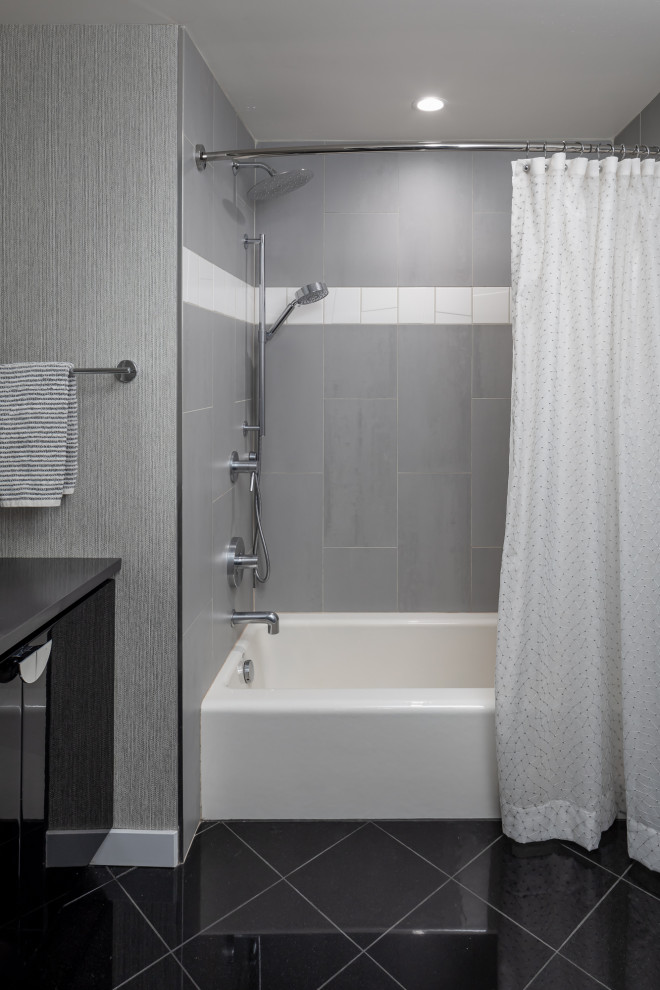 Photo of a mid-sized contemporary master bathroom in Seattle with flat-panel cabinets, black cabinets, an alcove tub, a shower/bathtub combo, a one-piece toilet, gray tile, porcelain tile, grey walls, marble floors, an undermount sink, engineered quartz benchtops, black floor, a shower curtain, grey benchtops, a single vanity and a built-in vanity.