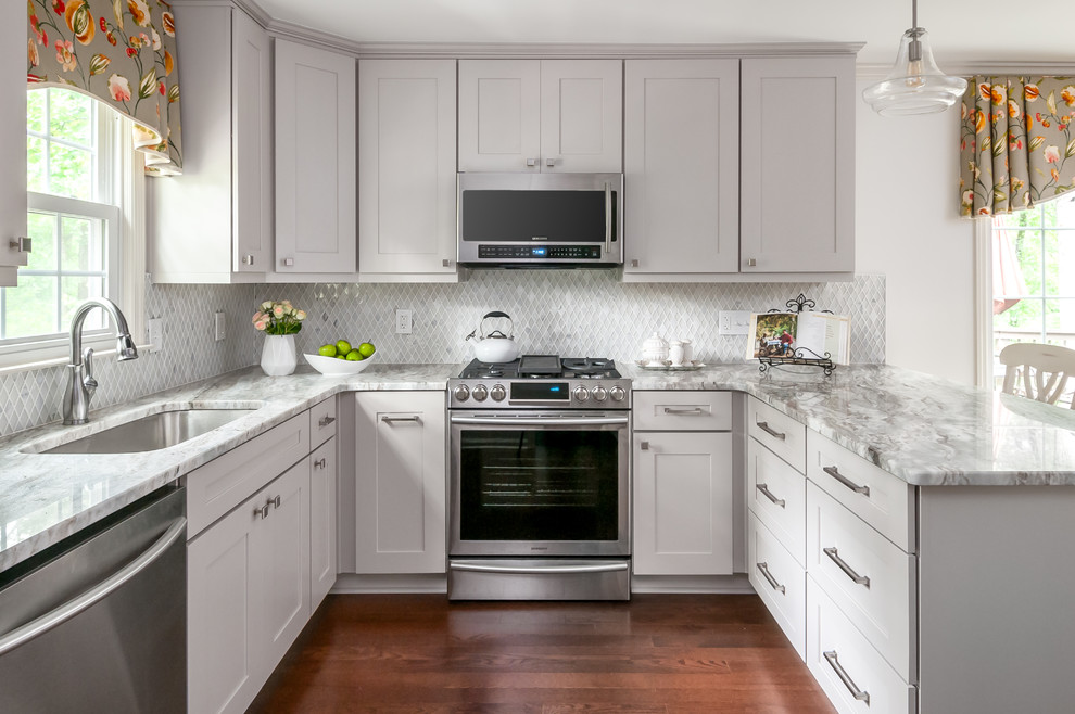 Inspiration for a traditional u-shaped kitchen in Atlanta with an undermount sink, shaker cabinets, grey cabinets, grey splashback, stainless steel appliances, dark hardwood floors, a peninsula and grey benchtop.
