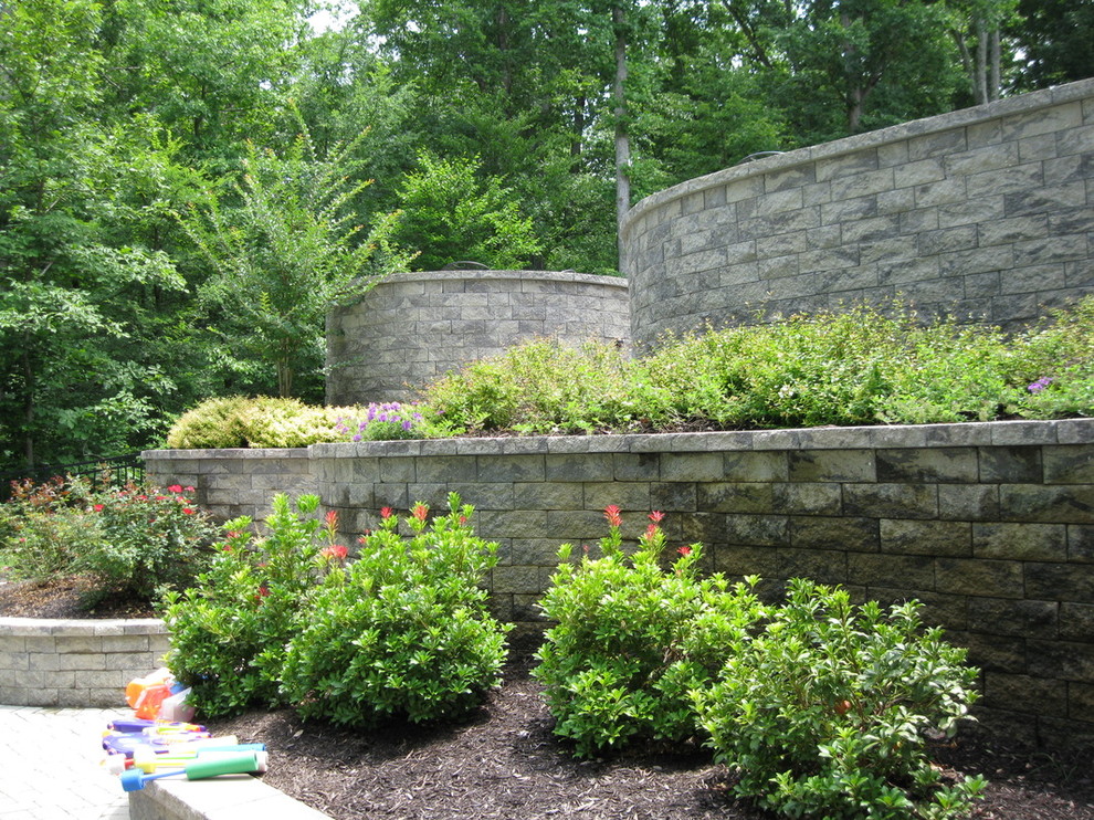 Mid-sized traditional backyard partial sun garden in Richmond with a retaining wall and natural stone pavers for spring.