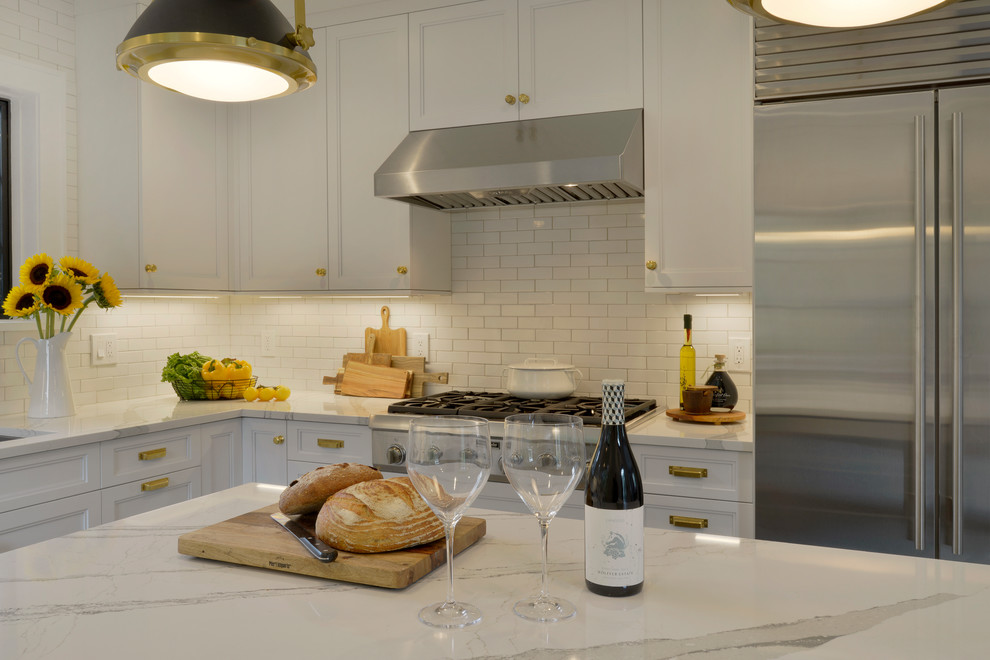 Example of a small transitional u-shaped porcelain tile and gray floor enclosed kitchen design in New York with an undermount sink, recessed-panel cabinets, white cabinets, quartz countertops, white backsplash, ceramic backsplash, stainless steel appliances, an island and white countertops