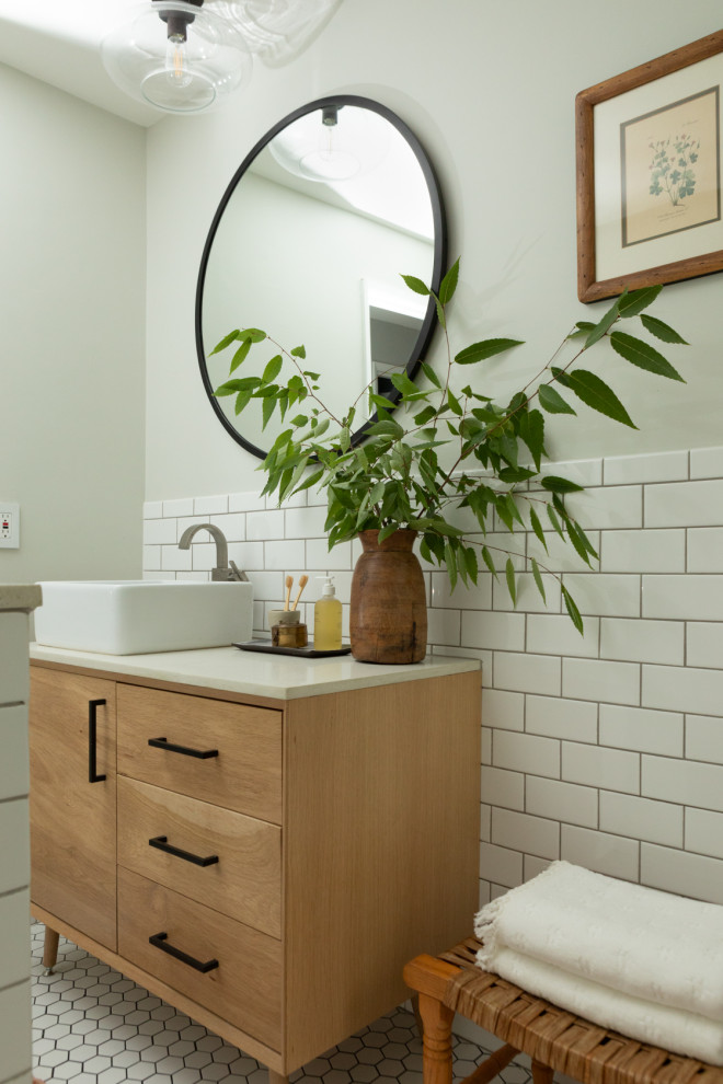 Пример оригинального дизайна: маленькая ванная комната в стиле ретро с плоскими фасадами, светлыми деревянными фасадами, ванной в нише, душем над ванной, унитазом-моноблоком, белой плиткой, керамической плиткой, серыми стенами, полом из керамогранита, настольной раковиной, столешницей из искусственного кварца, белым полом, душем с распашными дверями, белой столешницей, нишей, тумбой под одну раковину и напольной тумбой для на участке и в саду