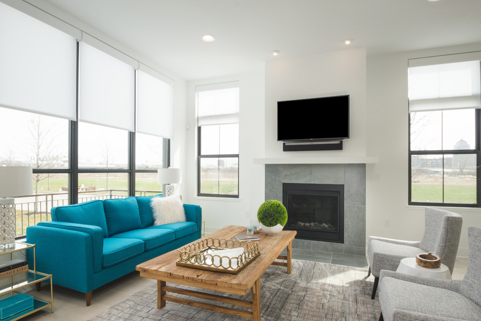 This is an example of a mid-sized modern open concept living room in Columbus with white walls, light hardwood floors, a standard fireplace and a tile fireplace surround.