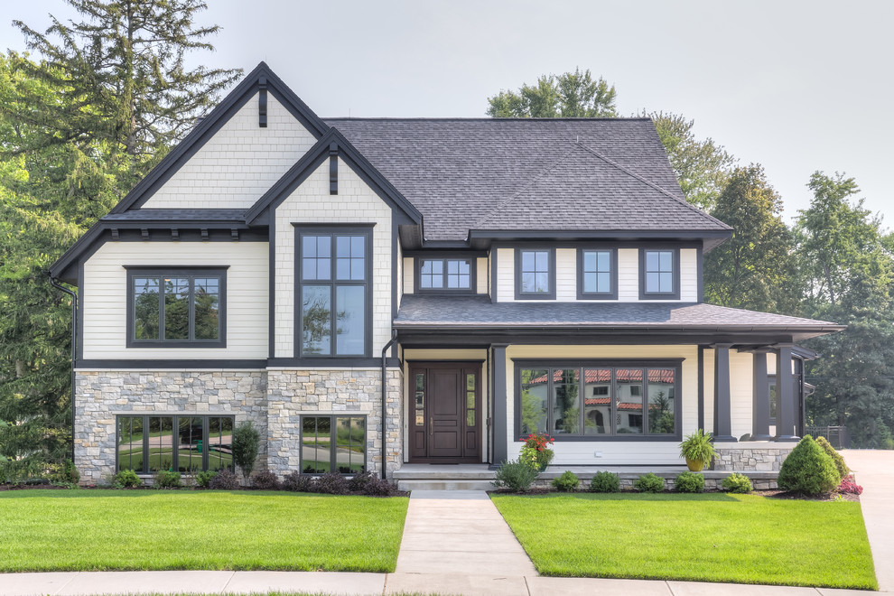 Design ideas for a transitional split-level house exterior in Grand Rapids with stone veneer and a gable roof.