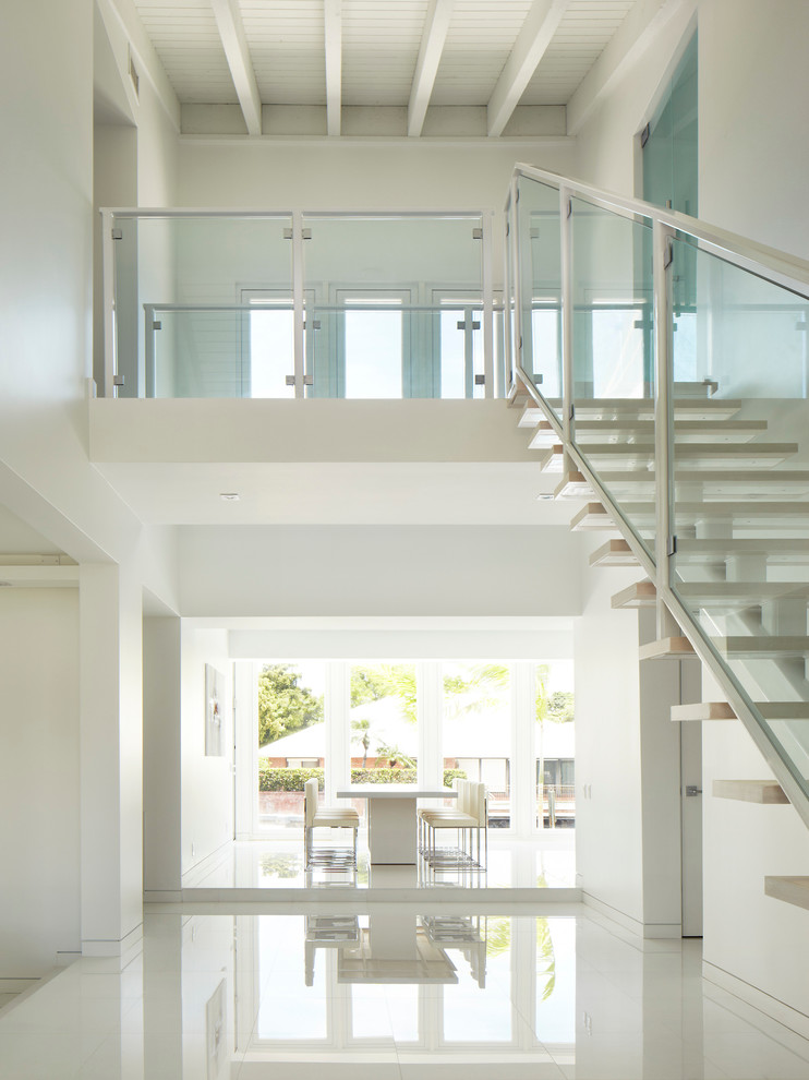 Contemporary wood straight staircase in Miami with open risers.