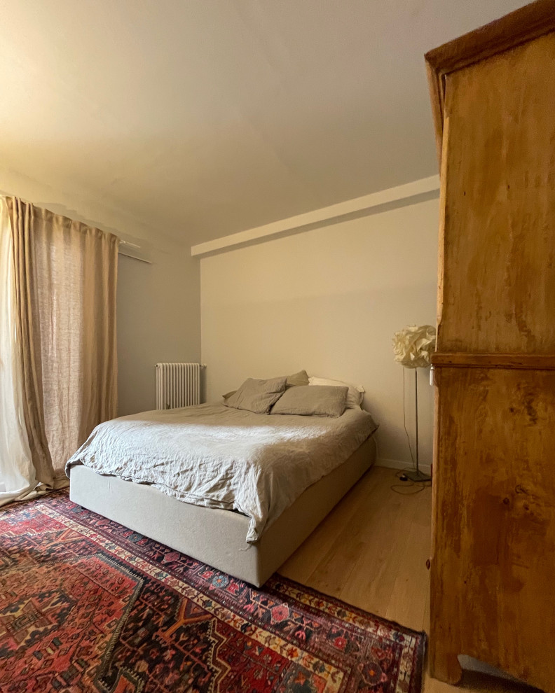 Esempio di una piccola camera matrimoniale moderna con pareti grigie, pavimento in legno massello medio e pavimento beige