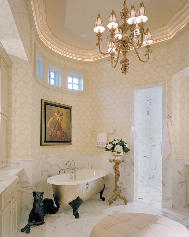 Photo of a mediterranean bathroom in Charlotte with a claw-foot tub and marble benchtops.