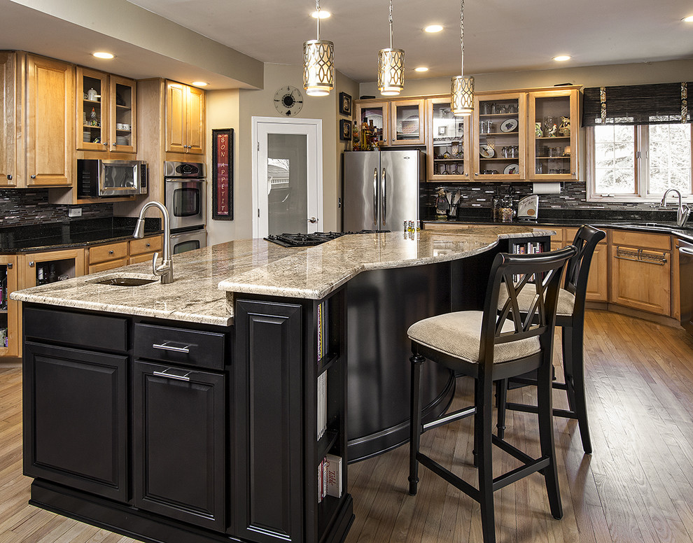 Inspiration for a large transitional u-shaped separate kitchen in Chicago with an undermount sink, raised-panel cabinets, medium wood cabinets, granite benchtops, black splashback, matchstick tile splashback, stainless steel appliances, medium hardwood floors and with island.