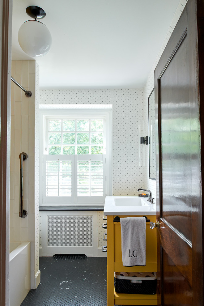 Idéer för ett litet modernt vit badrum för barn, med släta luckor, gula skåp, ett badkar i en alkov, en dusch/badkar-kombination, en toalettstol med hel cisternkåpa, vit kakel, keramikplattor, vita väggar, klinkergolv i porslin, ett integrerad handfat, svart golv och dusch med duschdraperi