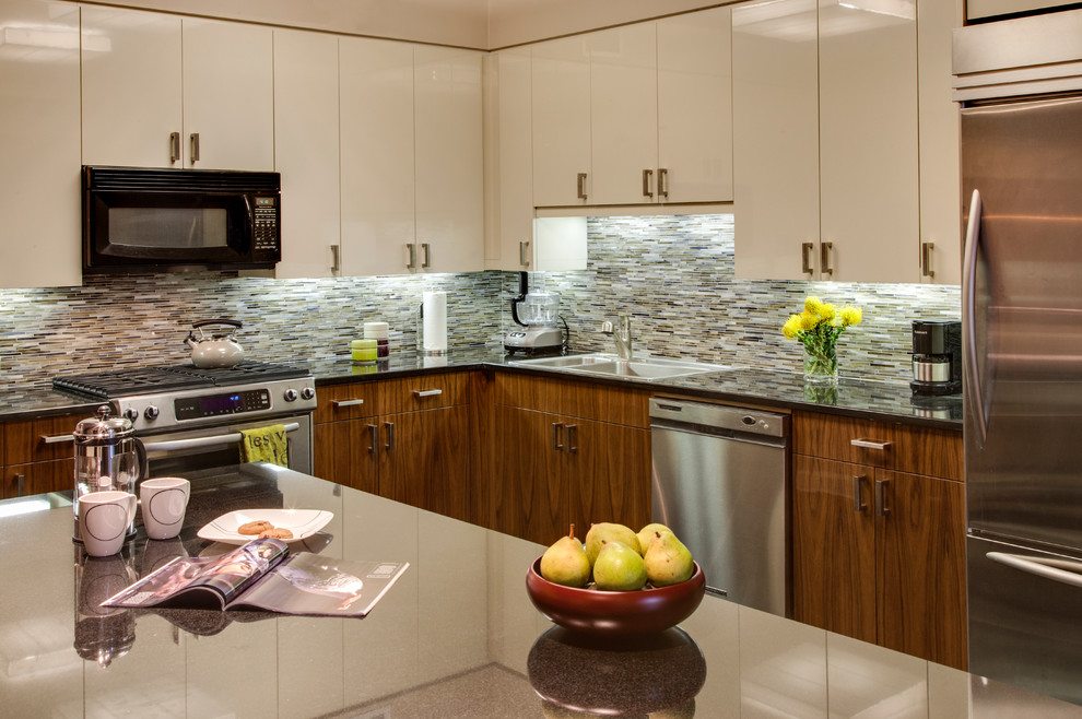 Contemporary kitchen in New York with a double-bowl sink, flat-panel cabinets, beige cabinets, multi-coloured splashback, matchstick tile splashback and stainless steel appliances.