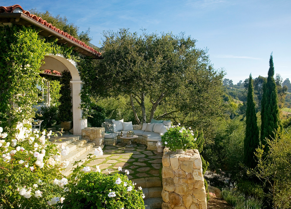 Mediterranean sloped partial sun garden in Santa Barbara with a retaining wall.