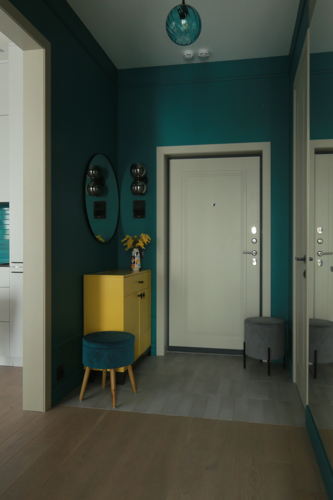 Modelo de puerta principal actual pequeña con paredes verdes, suelo de baldosas de porcelana, puerta simple, puerta gris y suelo gris