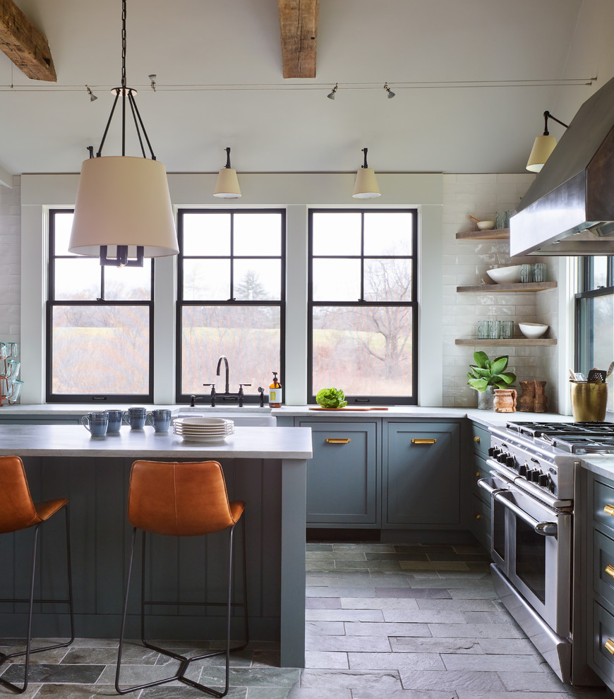 Inspiration for a mid-sized transitional l-shaped separate kitchen in Boston with a farmhouse sink, shaker cabinets, blue cabinets, quartzite benchtops, white splashback, subway tile splashback, stainless steel appliances, slate floors, with island, grey floor and white benchtop.