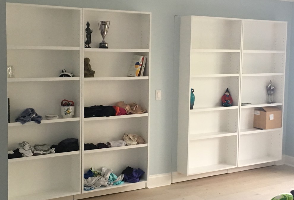 Example of a mid-sized beach style gender-neutral reach-in closet design in Miami with flat-panel cabinets and white cabinets