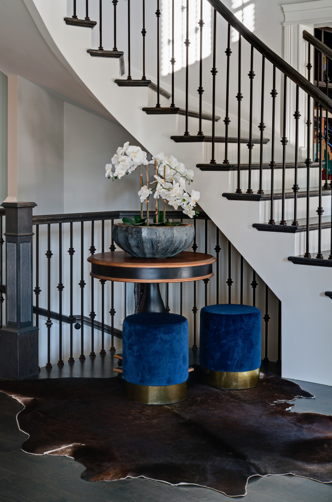 Expansive transitional wood curved staircase in Chicago with painted wood risers and wood railing.