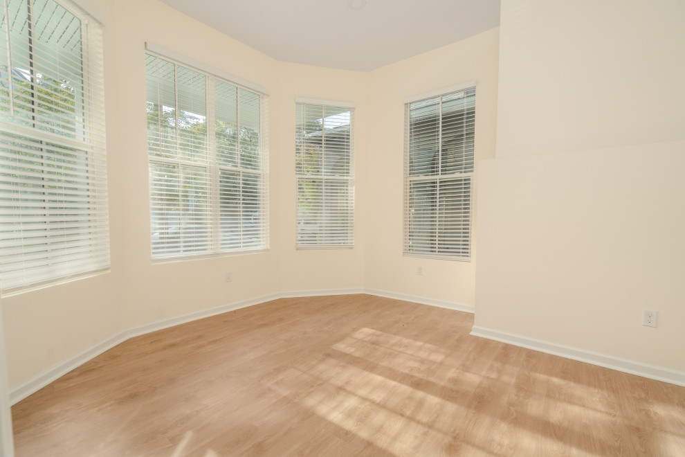 Bild på ett mellanstort amerikanskt gästrum, med beige väggar, vinylgolv och brunt golv