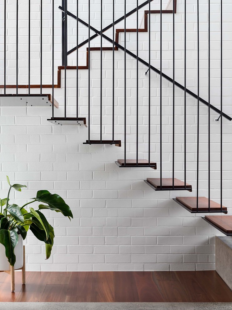 Contemporary wood floating staircase in Melbourne with metal risers and metal railing.