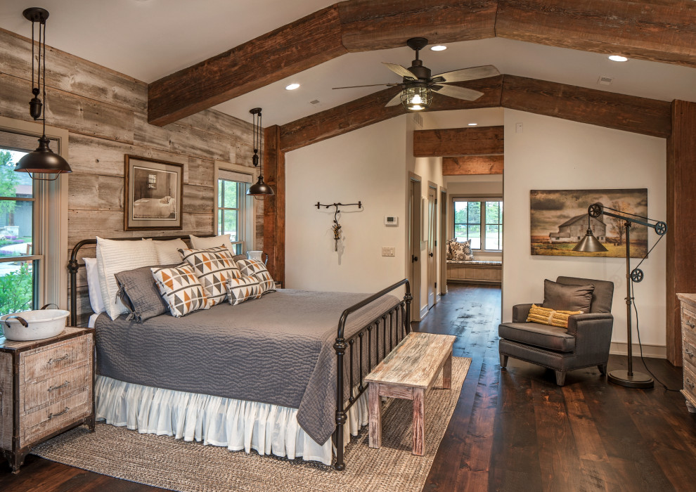 This is an example of a country bedroom in Omaha with white walls, dark hardwood floors and brown floor.