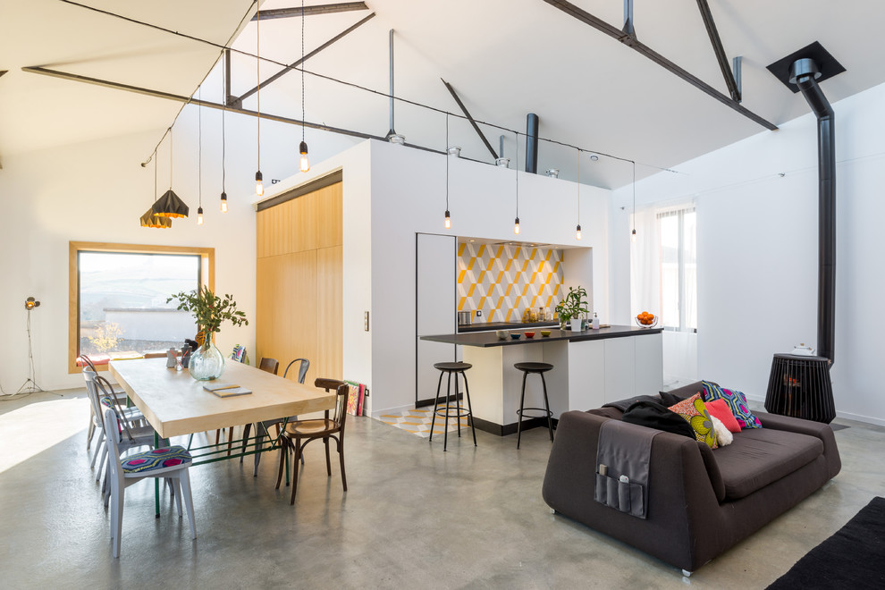 This is an example of a mid-sized industrial open plan kitchen in Lyon with concrete floors.