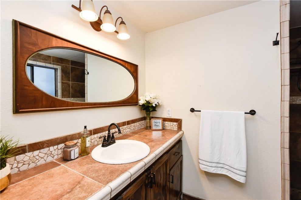 Small traditional master bathroom in Seattle with porcelain tile, white walls, porcelain floors, an open shower, furniture-like cabinets, dark wood cabinets, a corner shower, a two-piece toilet, red tile, a drop-in sink, tile benchtops, red floor, red benchtops, a single vanity and a built-in vanity.