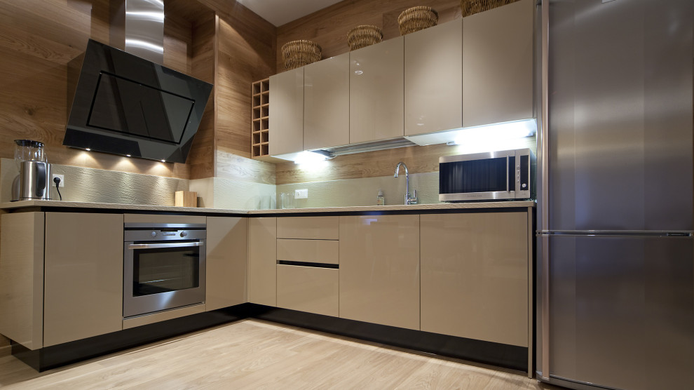 Mid-sized modern l-shaped kitchen in Los Angeles with an integrated sink, flat-panel cabinets, white cabinets, laminate benchtops, beige splashback, terra-cotta splashback, stainless steel appliances, painted wood floors, no island, beige floor and beige benchtop.
