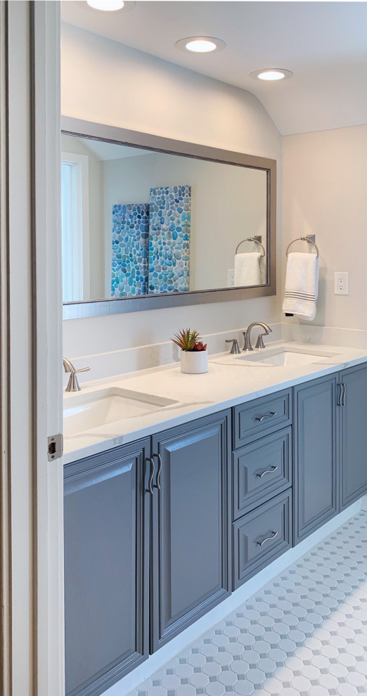Photo of a mid-sized contemporary kids bathroom with raised-panel cabinets, grey cabinets, an alcove tub, a shower/bathtub combo, a one-piece toilet, white tile, subway tile, white walls, marble floors, an undermount sink, engineered quartz benchtops, white floor, a shower curtain, white benchtops, a niche, a double vanity, a built-in vanity and vaulted.