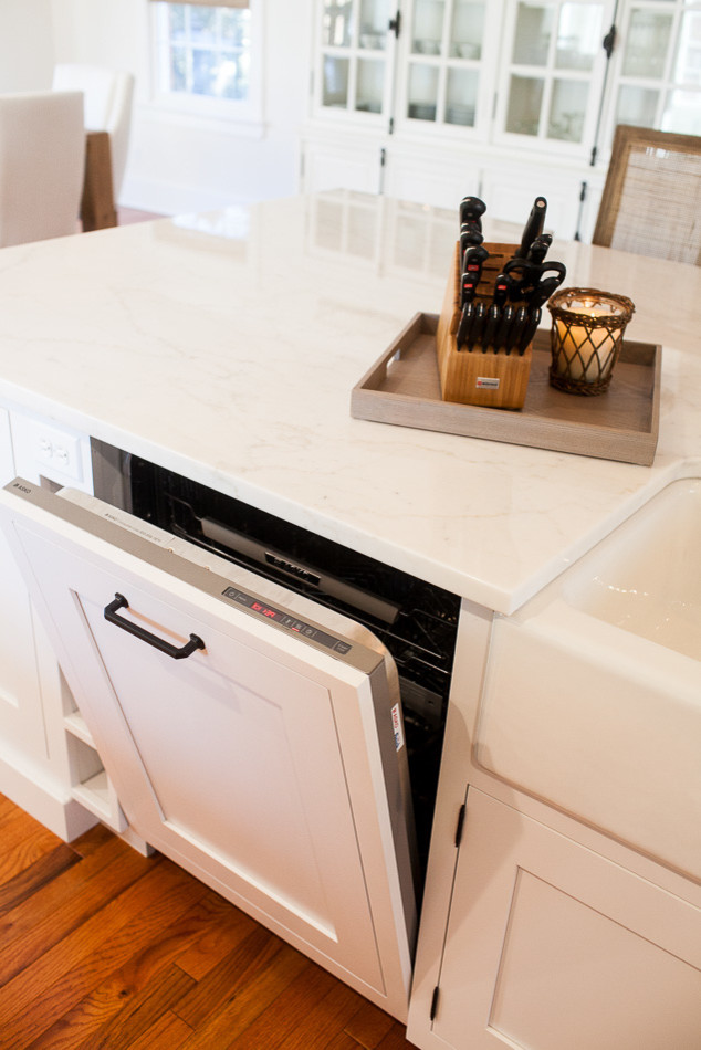 Eat-in kitchen - mid-sized transitional medium tone wood floor eat-in kitchen idea in St Louis with a farmhouse sink, flat-panel cabinets, white cabinets, white backsplash, subway tile backsplash, stainless steel appliances and an island