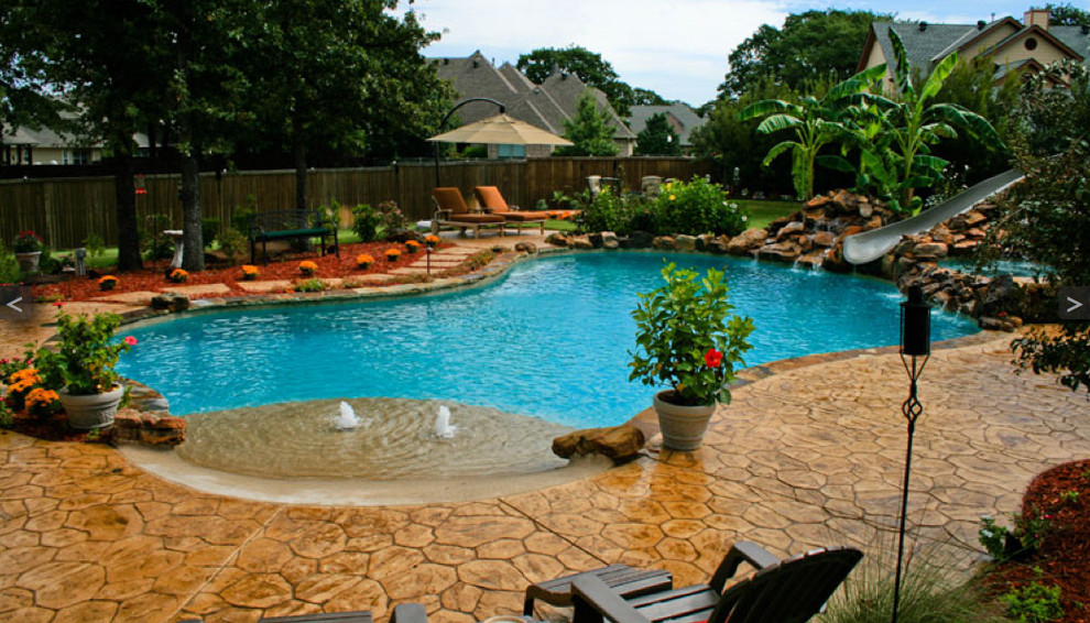 Photo of a contemporary backyard custom-shaped pool in Dallas with a water slide and stamped concrete.
