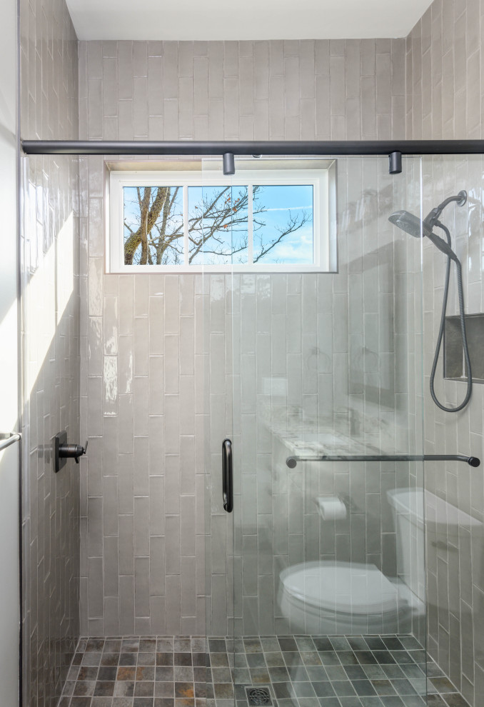 Transitional 3/4 gray tile and ceramic tile ceramic tile walk-in shower photo with gray cabinets, gray walls, an undermount sink and multicolored countertops