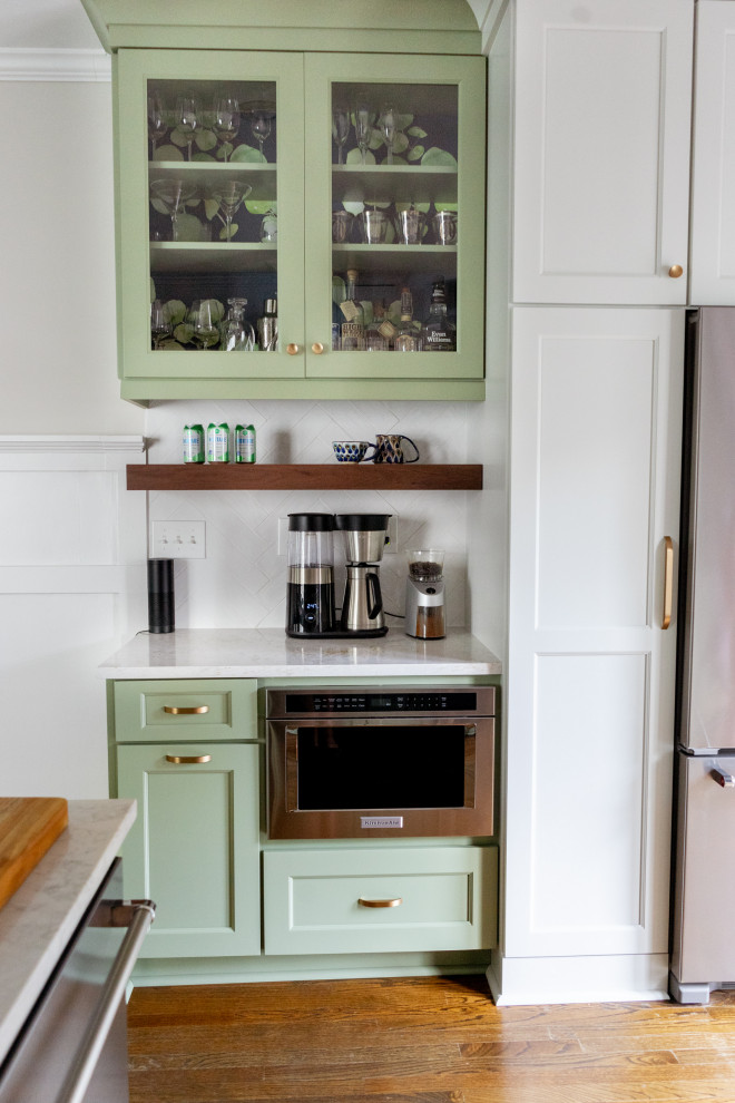 Design ideas for a small eclectic l-shaped eat-in kitchen in Atlanta with a single-bowl sink, shaker cabinets, green cabinets, quartz benchtops, white splashback, ceramic splashback, stainless steel appliances, medium hardwood floors, a peninsula, brown floor and multi-coloured benchtop.