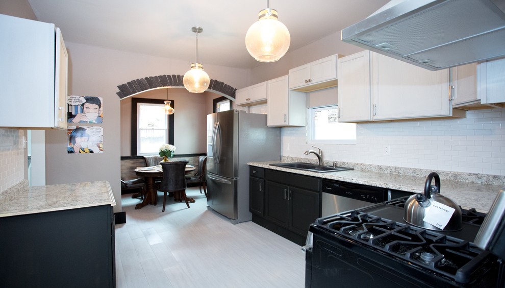 Enclosed kitchen - mid-sized transitional l-shaped vinyl floor and white floor enclosed kitchen idea with a double-bowl sink, recessed-panel cabinets, black cabinets, laminate countertops, white backsplash, subway tile backsplash, stainless steel appliances and gray countertops