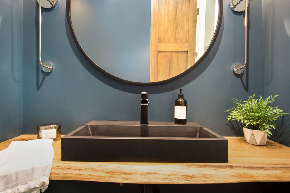 Inspiration for a rustic 3/4 medium tone wood floor bathroom remodel in Grand Rapids with brown cabinets, a vessel sink and wood countertops