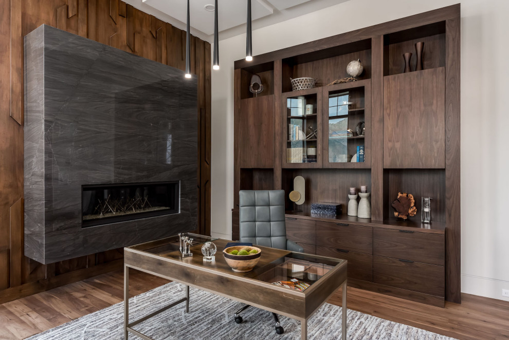 Large modern study room in Salt Lake City with white walls, dark hardwood floors, a hanging fireplace, a tile fireplace surround, a freestanding desk, brown floor and coffered.