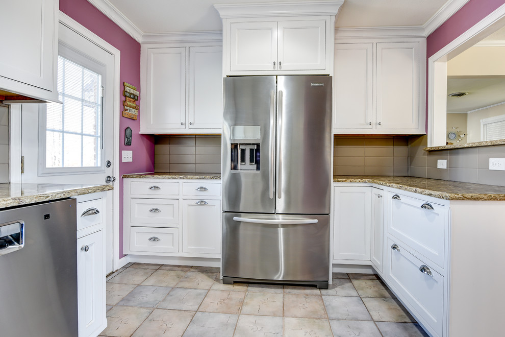 Example of a mid-sized classic u-shaped ceramic tile eat-in kitchen design with an undermount sink, recessed-panel cabinets, white cabinets, granite countertops, beige backsplash, ceramic backsplash, stainless steel appliances and no island