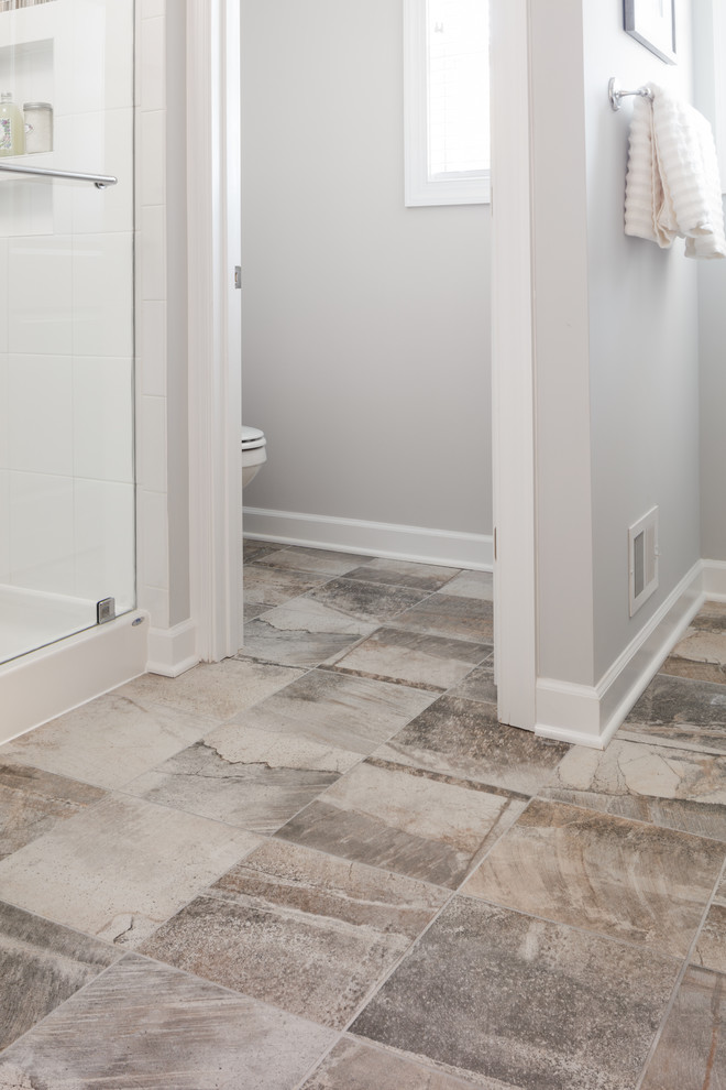 Design ideas for a mid-sized transitional master bathroom in Other with shaker cabinets, brown cabinets, an alcove shower, white tile, ceramic tile, blue walls, ceramic floors, an integrated sink, solid surface benchtops, brown floor, a hinged shower door and white benchtops.