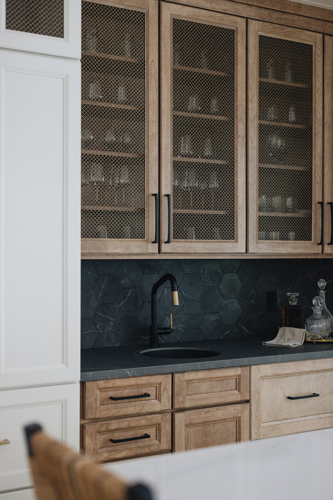 Wet Bar in Kitchen - Wet bar featuring black marble hexagon tile backsplash, hickory cabinets with metal mesh insets, white cabinets, black hardware, round bar sink, and mixed metal faucet.