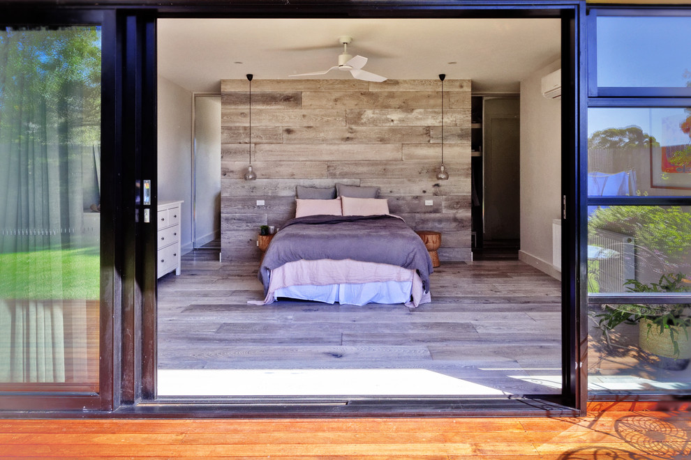 Inspiration for a mid-sized contemporary bedroom in Melbourne with light hardwood floors, no fireplace and grey floor.