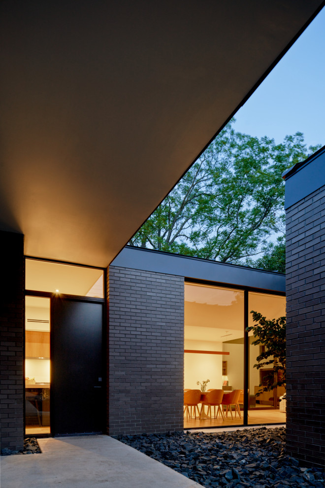Свежая идея для дизайна: одноэтажный, кирпичный, коричневый частный загородный дом в стиле модернизм с вальмовой крышей, металлической крышей и черной крышей - отличное фото интерьера