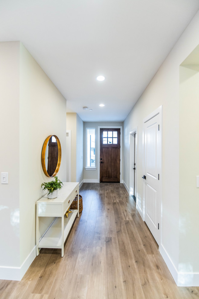 Inspiration for a mid-sized transitional front door in Sacramento with beige walls, laminate floors, a single front door and a medium wood front door.