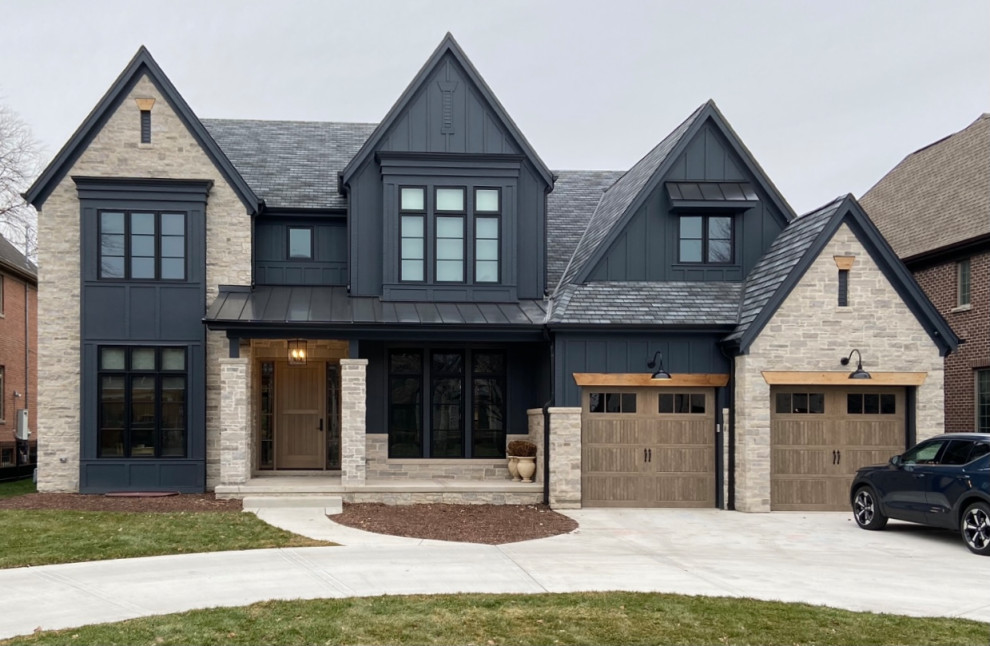 This is an example of a transitional two-storey black house exterior in Chicago with stone veneer, a gable roof, a shingle roof, a grey roof and board and batten siding.