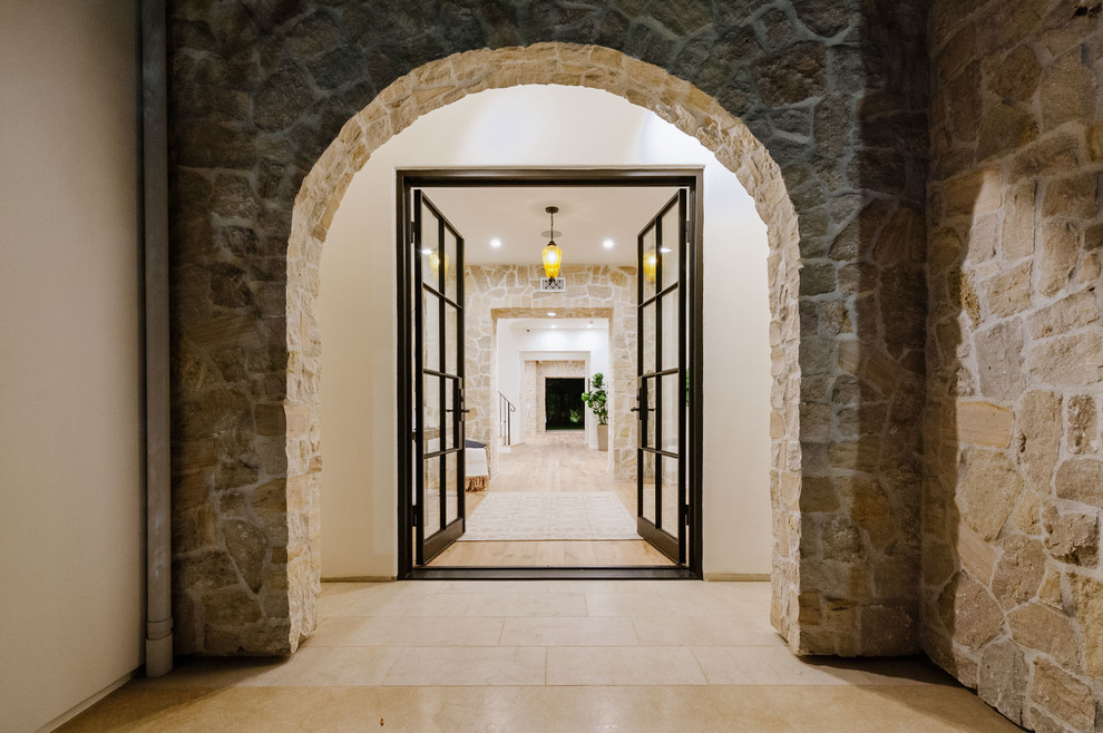 Inspiration for a large mediterranean entry hall in Los Angeles with a double front door and a black front door.