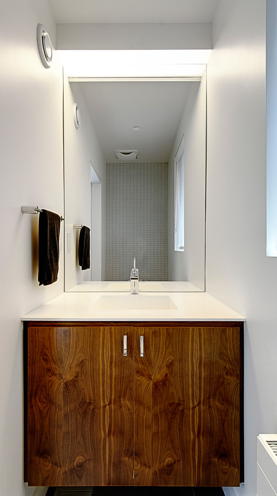 Design ideas for a small contemporary powder room in Toronto with an integrated sink, flat-panel cabinets, medium wood cabinets, white tile, ceramic tile and white walls.