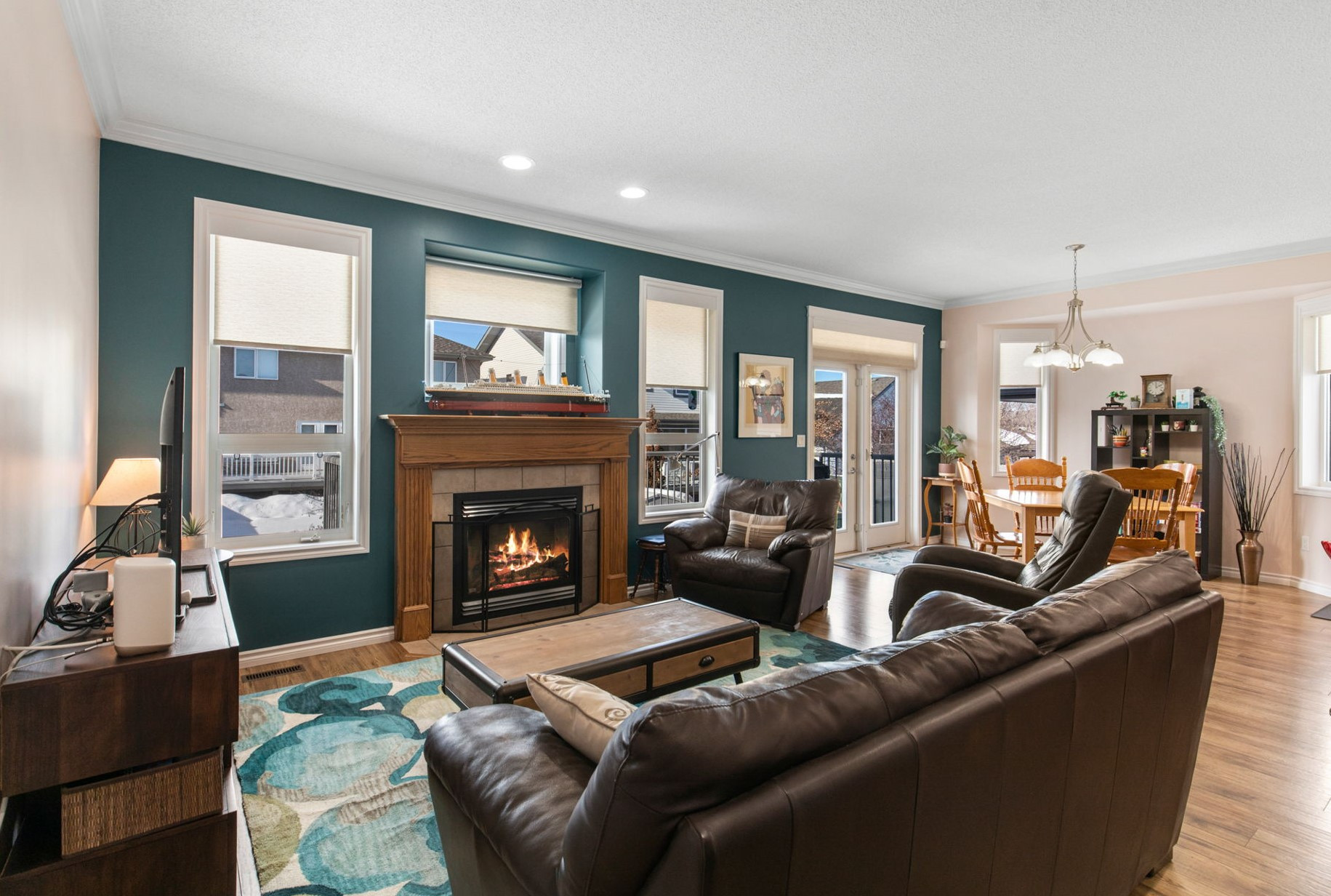 Beautiful living area with a complimenting accent wall with a beautiful wooden fireplace.