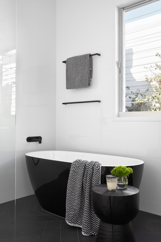 This is an example of a mid-sized contemporary master bathroom in Melbourne with a freestanding tub, an open shower, white walls, light wood cabinets, multi-coloured tile, mosaic tile, a drop-in sink, solid surface benchtops and black benchtops.