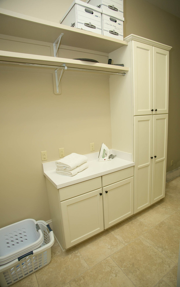 Photo of a mid-sized traditional galley dedicated laundry room in New Orleans with recessed-panel cabinets, white cabinets and a side-by-side washer and dryer.