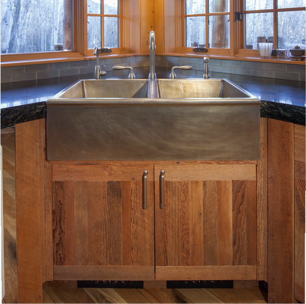 Inspiration for a mid-sized rustic l-shaped medium tone wood floor and brown floor kitchen remodel with a farmhouse sink, flat-panel cabinets, medium tone wood cabinets, stainless steel appliances and an island