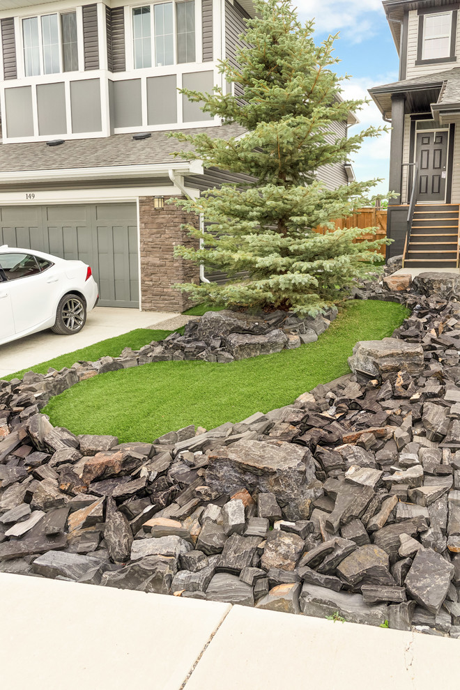Design ideas for a small country front yard full sun driveway in Calgary with a garden path and natural stone pavers.