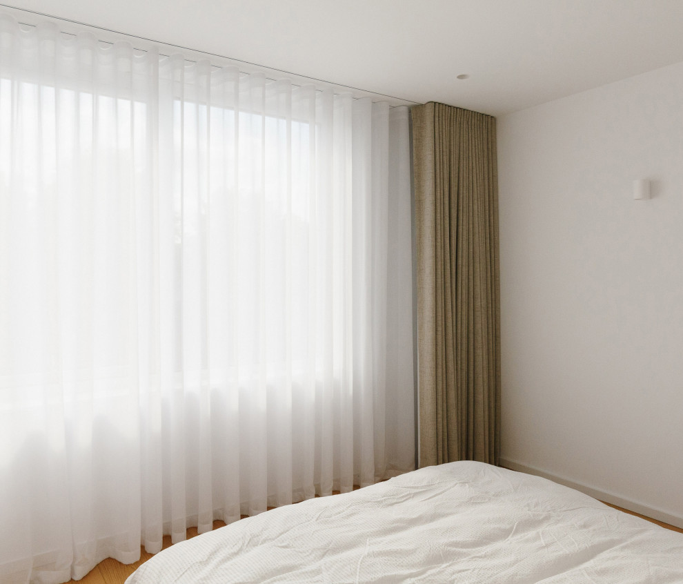 Mittelgroßes Modernes Schlafzimmer mit weißer Wandfarbe und braunem Holzboden in Manchester