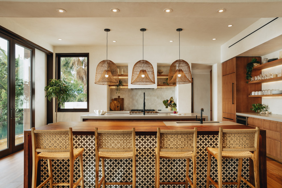 Photo of a large tropical eat-in kitchen in Other with an undermount sink, flat-panel cabinets, medium wood cabinets, quartz benchtops, multi-coloured splashback, mosaic tile splashback, panelled appliances, porcelain floors, multiple islands and grey benchtop.
