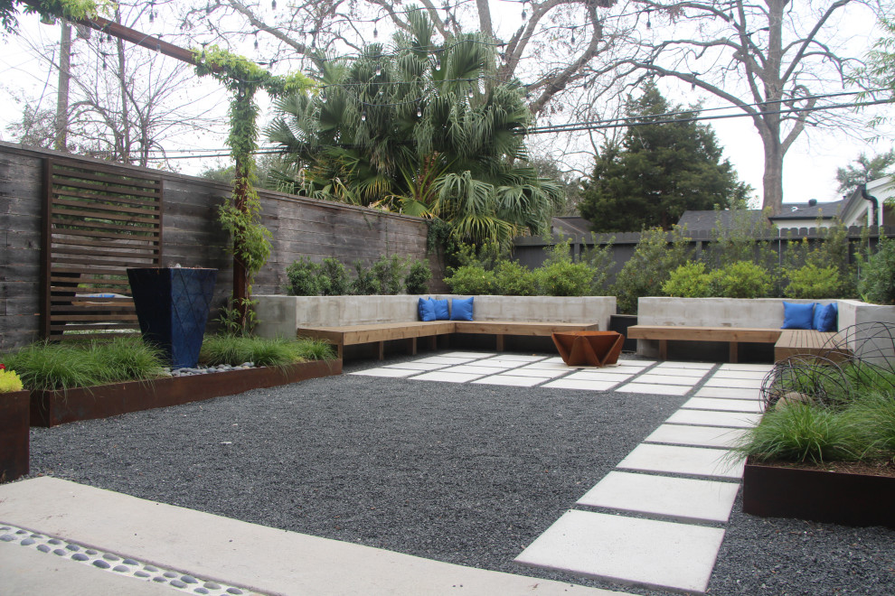 This is an example of a contemporary backyard full sun garden in Houston with with privacy feature.